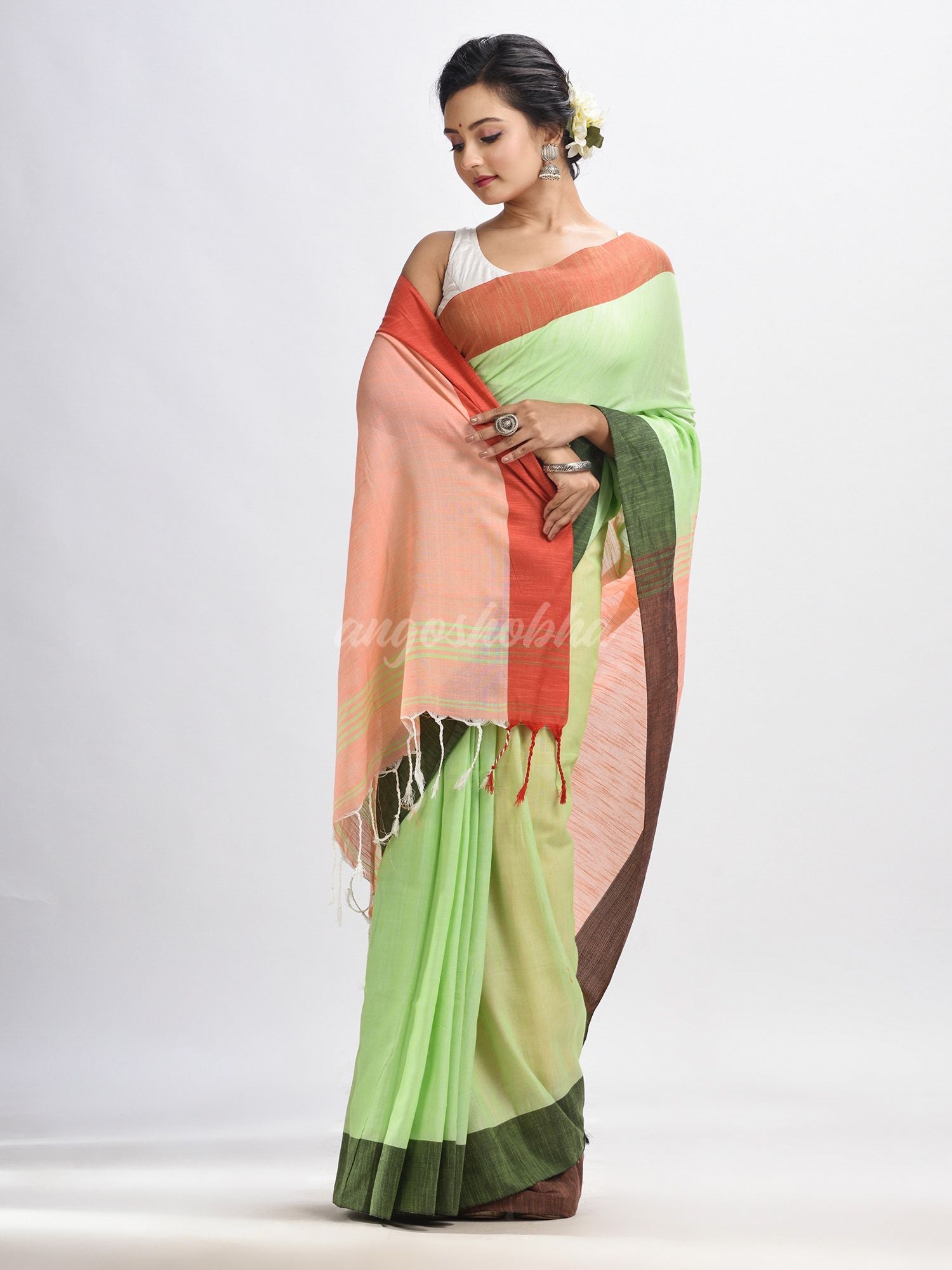 Light green cotton with solid body in tawny peach pallu handloom saree